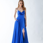 Sarah wearing a royal blue satin prom dress with a wrap-style bodice, side slit, and spaghetti straps.
