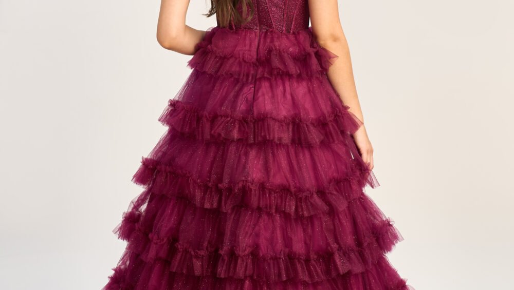 Model wears a beautiful pink prom gown with an open back, which contrasts perfectly with peach prom dresses for a romantic appearance.